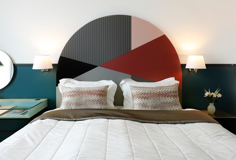Bed with colorful headbord. Photo.