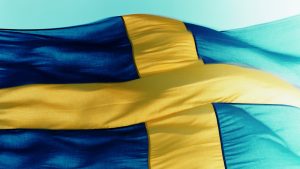The Swedish national flag, with a yellow cross on blue. Illustration.
