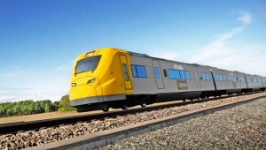 A yellow painted modern looking train passing on the rail. Photo.